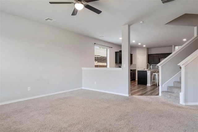 11325 SW 34th Ter, Yukon, OK 73099 - unfurnished living room with carpet, ceiling fan, baseboards, recessed lighting, and a sink