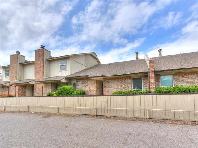 10125 N Pennsylvania Ave Unit 4, Oklahoma City, OK 73120 - view of front of home with brick siding, roof with shingles, and a chimney