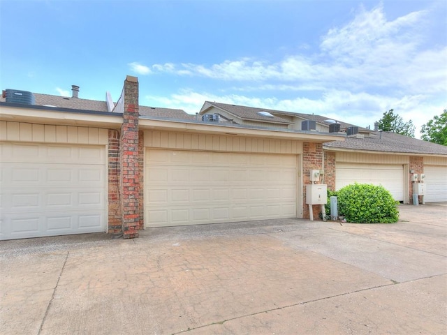 10125 N Pennsylvania Ave Unit 4, Oklahoma City, OK 73120 - view of front of house featuring brick siding, community garages, and a shingled roof