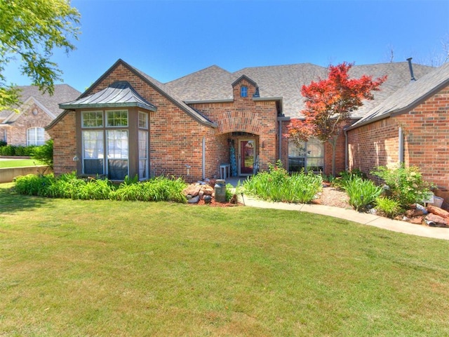 19609 Filly Dr, Edmond, OK 73003 - tudor home with brick siding, a front yard, and roof with shingles