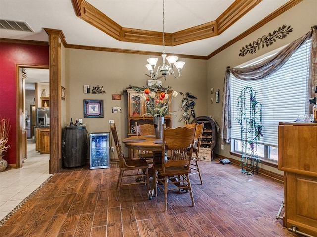 19609 Filly Dr, Edmond, OK 73003 - dining room with baseboards, a tray ceiling, a chandelier, ornamental molding, and wood finished floors