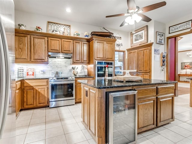 19609 Filly Dr, Edmond, OK 73003 - kitchen featuring appliances with stainless steel finishes, beverage cooler, under cabinet range hood, light tile patterned floors, and brown cabinetry