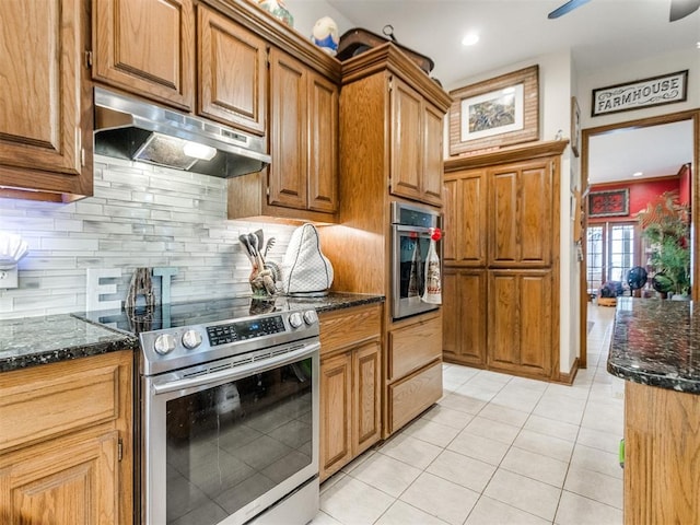 19609 Filly Dr, Edmond, OK 73003 - kitchen featuring stainless steel appliances, under cabinet range hood, dark stone counters, backsplash, and recessed lighting