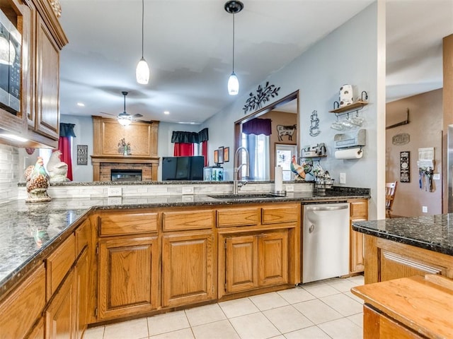 19609 Filly Dr, Edmond, OK 73003 - kitchen with a sink, appliances with stainless steel finishes, a fireplace, ceiling fan, and decorative backsplash