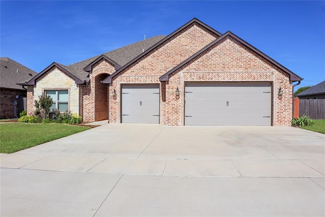 1417 Dustbowl Ln, Altus, OK 73521 - french country inspired facade featuring an attached garage, brick siding, concrete driveway, and a front lawn