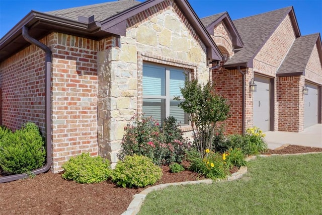 1417 Dustbowl Ln, Altus, OK 73521 - view of side of home featuring brick siding, an attached garage, concrete driveway, roof with shingles, and stone siding