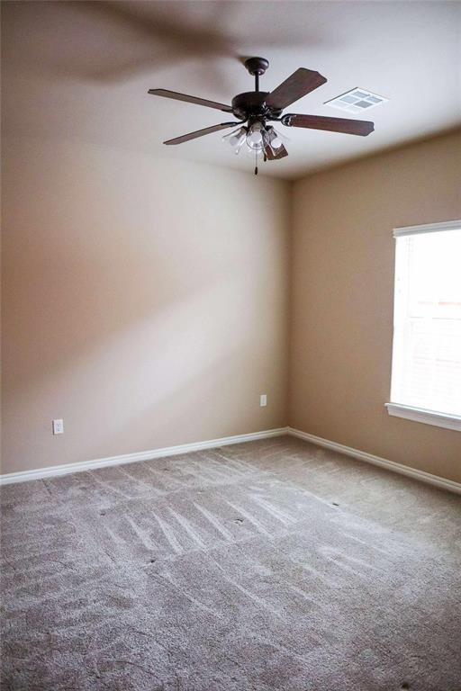 1417 Dustbowl Ln, Altus, OK 73521 - empty room with carpet floors, a ceiling fan, and baseboards