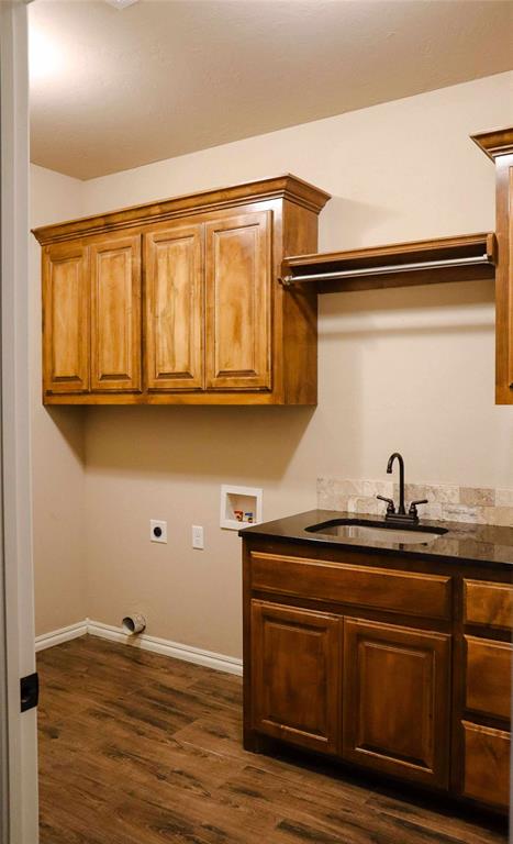 1417 Dustbowl Ln, Altus, OK 73521 - laundry room with cabinet space, electric dryer hookup, dark wood finished floors, washer hookup, and baseboards