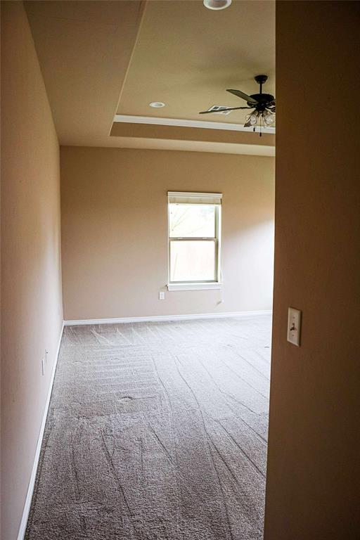 1417 Dustbowl Ln, Altus, OK 73521 - carpeted spare room featuring a ceiling fan, baseboards, a raised ceiling, and recessed lighting