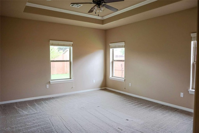 1417 Dustbowl Ln, Altus, OK 73521 - spare room featuring a tray ceiling, ceiling fan, crown molding, carpet floors, and healthy amount of natural light