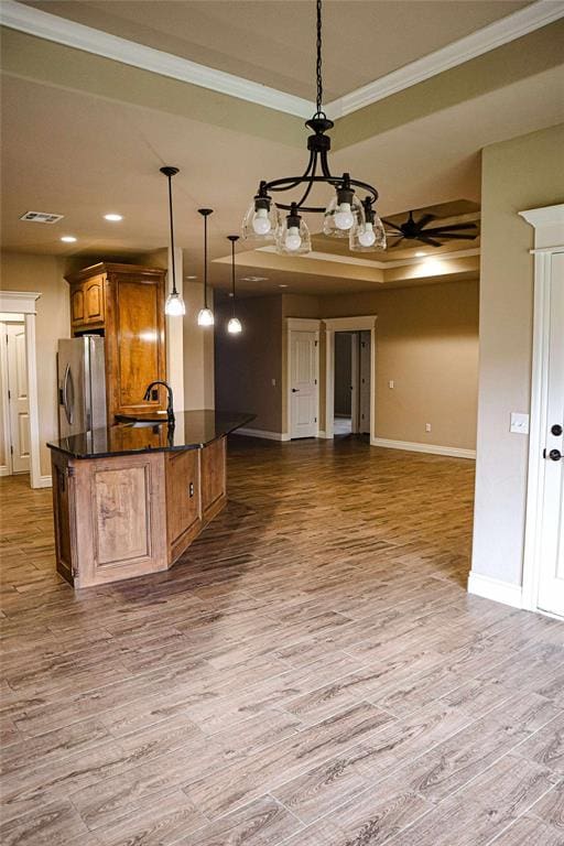1417 Dustbowl Ln, Altus, OK 73521 - kitchen featuring stainless steel fridge, open floor plan, brown cabinets, baseboards, and wood finished floors