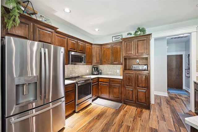 4706 Red Hawk St, Guthrie, OK 73044 - kitchen featuring appliances with stainless steel finishes, light countertops, wood finished floors, tasteful backsplash, and recessed lighting