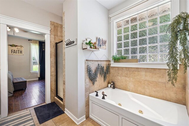 4706 Red Hawk St, Guthrie, OK 73044 - ensuite bathroom featuring a jetted tub, healthy amount of natural light, a stall shower, and baseboards