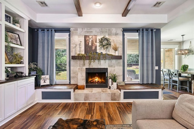 4706 Red Hawk St, Guthrie, OK 73044 - living area featuring a tiled fireplace, wood finished floors, and beamed ceiling