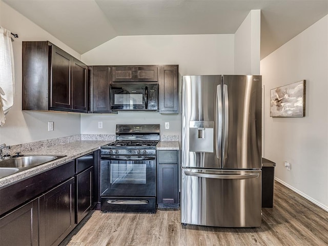 11621 Jude Way, Yukon, OK 73099 - kitchen featuring black appliances, dark brown cabinetry, lofted ceiling, light wood finished floors, and light countertops
