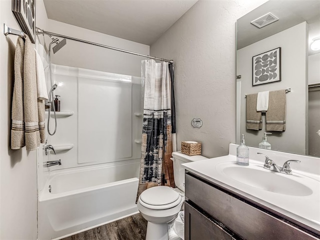 11621 Jude Way, Yukon, OK 73099 - bathroom with wood finished floors, vanity, shower / bath combination with curtain, a textured wall, and toilet