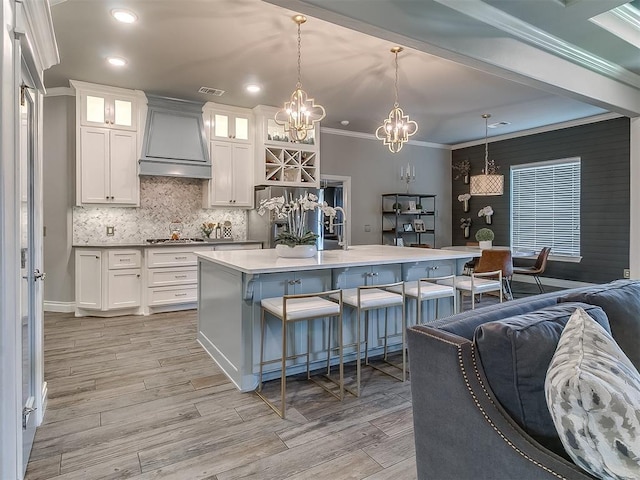 12801 Red Spruce Cir, Oklahoma City, OK 73142 - kitchen with custom range hood, a chandelier, crown molding, a breakfast bar, and open floor plan