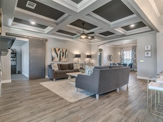 12801 Red Spruce Cir, Oklahoma City, OK 73142 - living area with a barn door, arched walkways, ceiling fan, wood finished floors, and crown molding