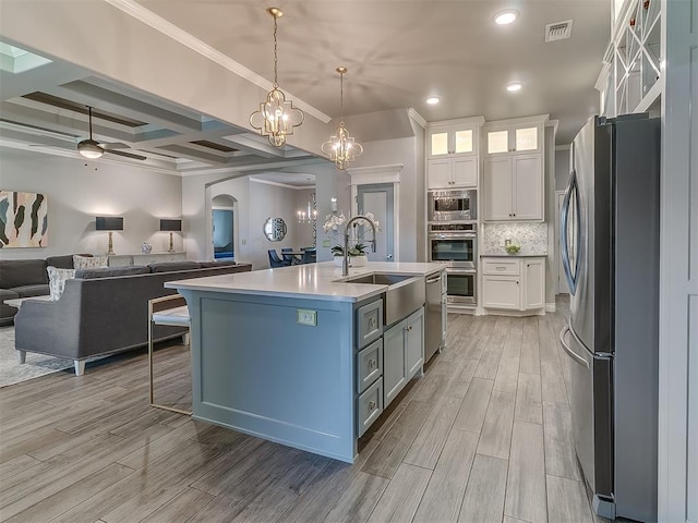 12801 Red Spruce Cir, Oklahoma City, OK 73142 - kitchen with appliances with stainless steel finishes, a sink, arched walkways, open floor plan, and a chandelier