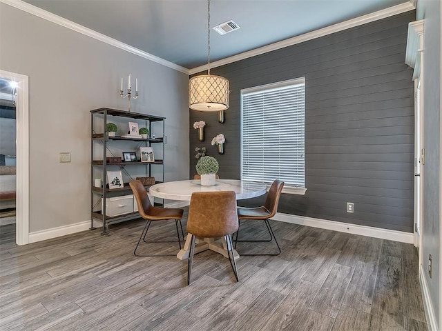 12801 Red Spruce Cir, Oklahoma City, OK 73142 - dining area with baseboards, wood finished floors, wood walls, and crown molding