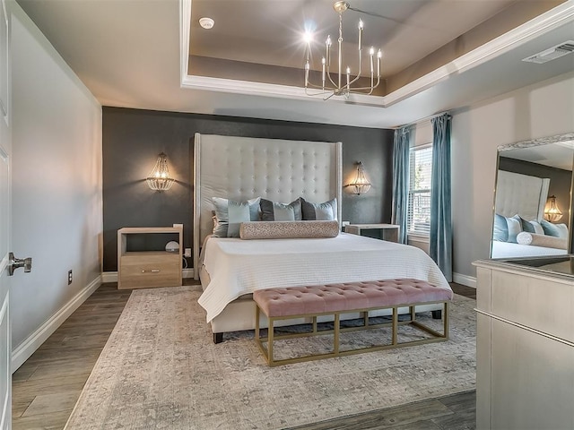 12801 Red Spruce Cir, Oklahoma City, OK 73142 - bedroom featuring a tray ceiling, wood finished floors, a chandelier, and baseboards