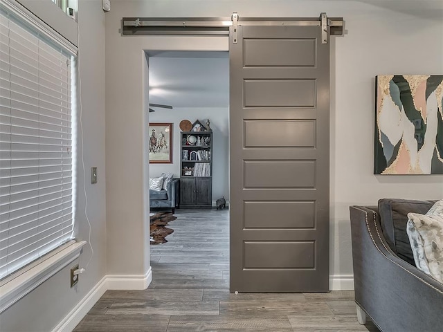 12801 Red Spruce Cir, Oklahoma City, OK 73142 - hallway featuring baseboards, wood finished floors, and a barn door