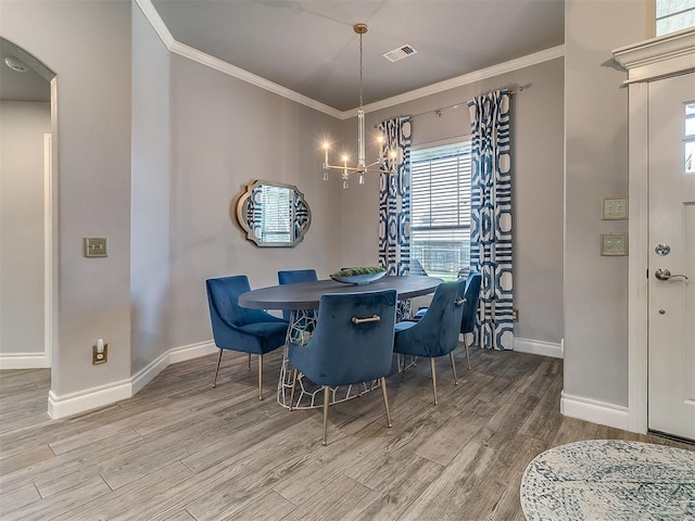 12801 Red Spruce Cir, Oklahoma City, OK 73142 - dining room with baseboards, ornamental molding, wood finished floors, a chandelier, and arched walkways