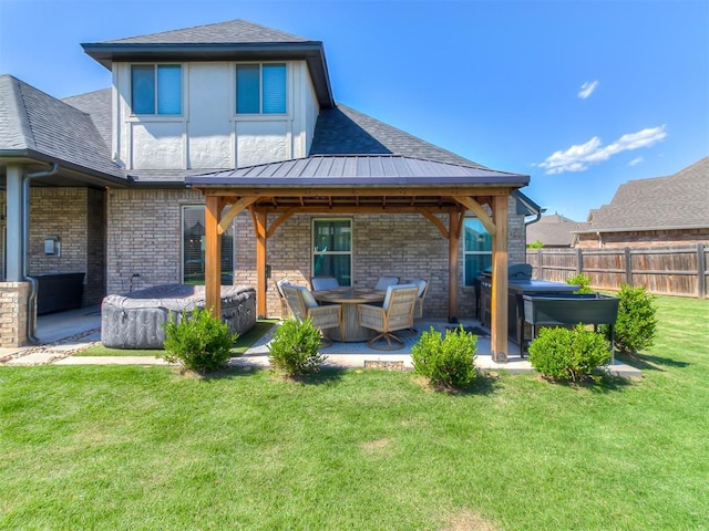 12801 Red Spruce Cir, Oklahoma City, OK 73142 - back of house with a hot tub, a patio area, a shingled roof, and brick siding