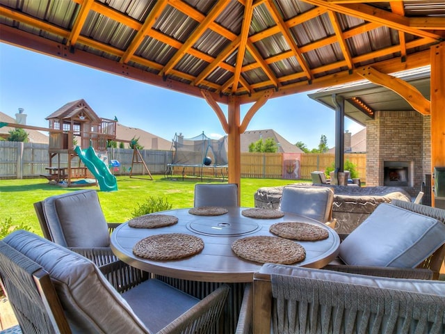 12801 Red Spruce Cir, Oklahoma City, OK 73142 - view of patio / terrace featuring a trampoline, an outdoor brick fireplace, and a playground