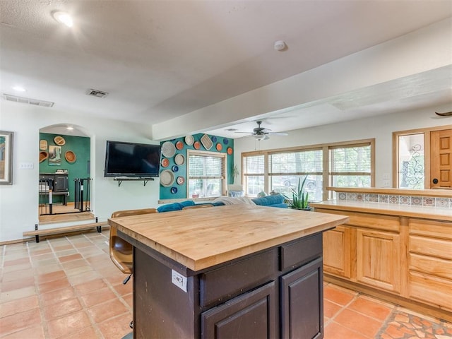 43 W Shore Dr, Arcadia, OK 73007 - kitchen with wooden counters, ceiling fan, a kitchen breakfast bar, arched walkways, and a center island