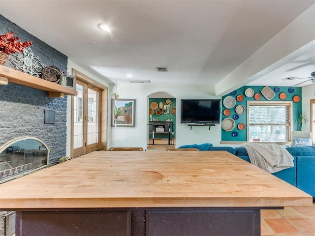 43 W Shore Dr, Arcadia, OK 73007 - dining space featuring a ceiling fan, french doors, arched walkways, and a fireplace