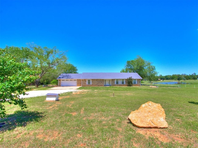 18 Whispering Meadows Rd, Shawnee, OK 74804 - ranch-style home featuring dirt driveway, an attached garage, a front yard, and a water view