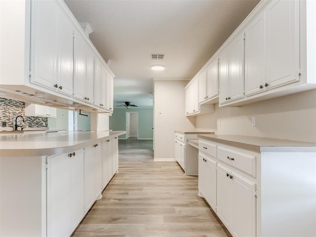 18 Whispering Meadows Rd, Shawnee, OK 74804 - kitchen with ceiling fan, decorative backsplash, light wood-type flooring, white cabinetry, and light countertops