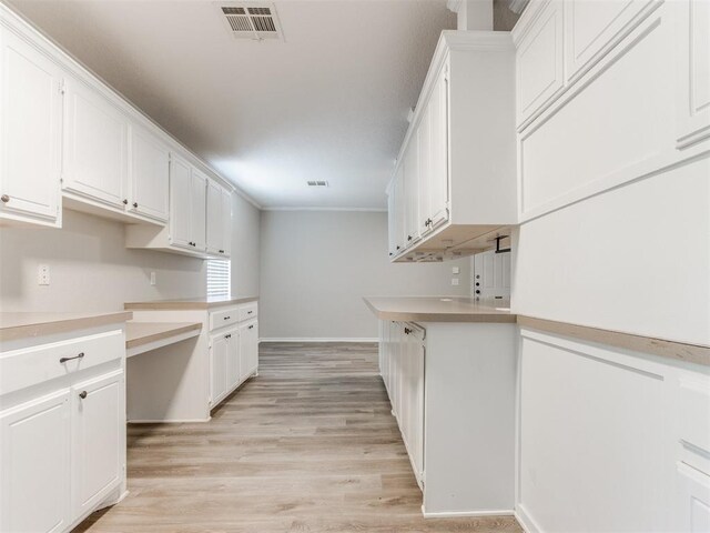 18 Whispering Meadows Rd, Shawnee, OK 74804 - kitchen featuring light wood-type flooring, baseboards, white cabinets, light countertops, and crown molding