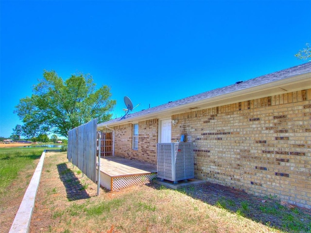 18 Whispering Meadows Rd, Shawnee, OK 74804 - view of side of home with central AC, brick siding, and a deck