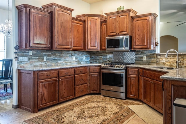 3417 Lyle Rd, Weatherford, OK 73096 - kitchen with stainless steel appliances, a sink, dark stone counters, tasteful backsplash, and decorative light fixtures