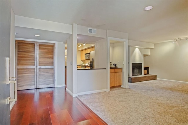 600 NW 4th St Unit 319N, Oklahoma City, OK 73102 - unfurnished living room with a fireplace with raised hearth, dark wood finished floors, and recessed lighting