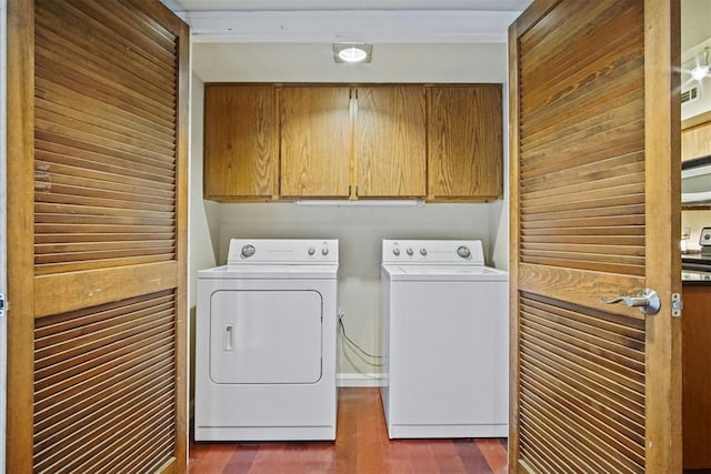 600 NW 4th St Unit 319N, Oklahoma City, OK 73102 - washroom featuring washer and dryer, cabinet space, and dark wood-style flooring