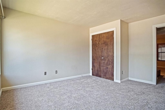 600 NW 4th St Unit 319N, Oklahoma City, OK 73102 - unfurnished bedroom featuring carpet flooring and a textured ceiling