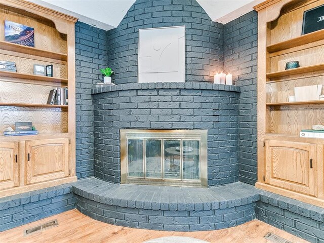 4205 Sooner Cir, Edmond, OK 73034 - detailed view of a brick fireplace and wood finished floors