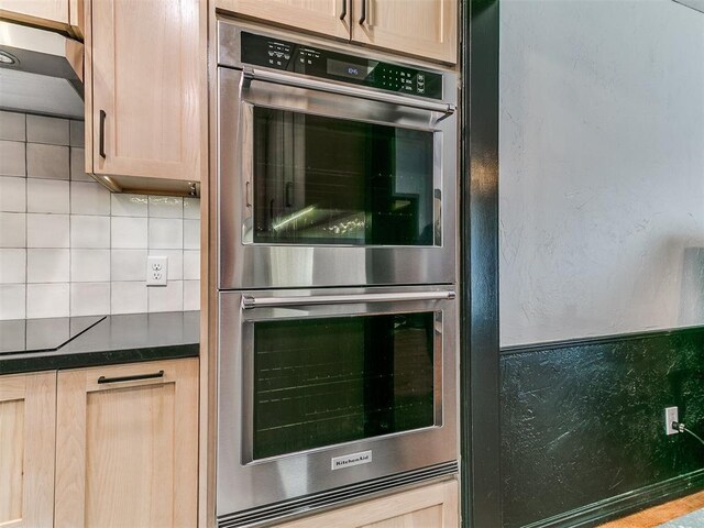 4205 Sooner Cir, Edmond, OK 73034 - kitchen with stainless steel double oven, extractor fan, dark countertops, backsplash, and black electric stovetop