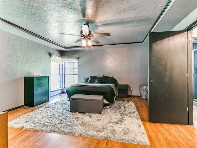 4205 Sooner Cir, Edmond, OK 73034 - bedroom with a textured wall, a textured ceiling, wood finished floors, and a ceiling fan