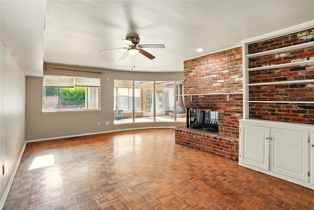 6005 NW Kingston Rd, Oklahoma City, OK 73122 - unfurnished living room featuring a ceiling fan, baseboards, and a brick fireplace