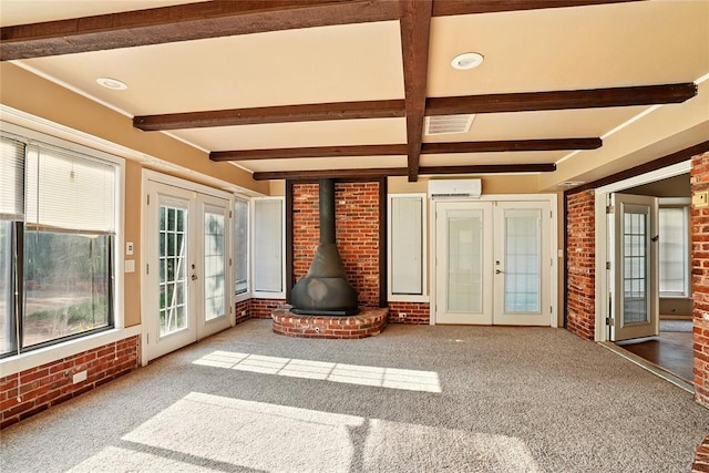 6005 NW Kingston Rd, Oklahoma City, OK 73122 - unfurnished sunroom with french doors, beam ceiling, an AC wall unit, and a wood stove
