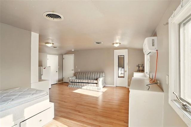 6005 NW Kingston Rd, Oklahoma City, OK 73122 - unfurnished bedroom featuring light wood-style flooring and a wall mounted AC