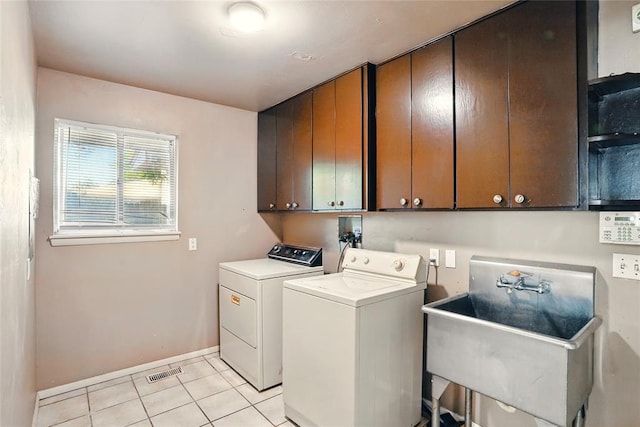 6005 NW Kingston Rd, Oklahoma City, OK 73122 - laundry room with separate washer and dryer, cabinet space, light tile patterned floors, and baseboards