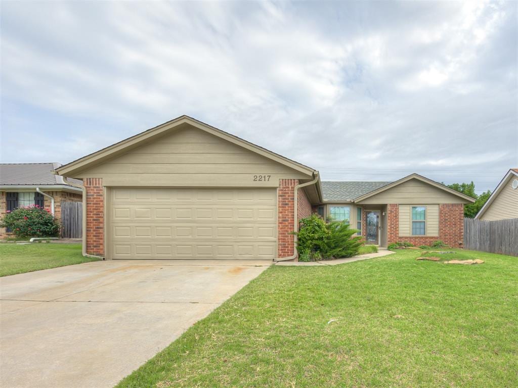 ranch-style house featuring brick siding, concrete driveway, and an attached garage
