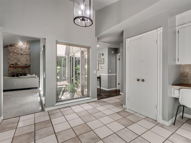 5101 Long Branch Ln, Edmond, OK 73034 - unfurnished dining area with light tile patterned floors, a high ceiling, and a stone fireplace