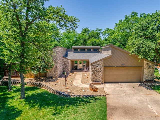 5101 Long Branch Ln, Edmond, OK 73034 - mid-century home featuring stone siding, an attached garage, driveway, a front lawn, and roof with shingles