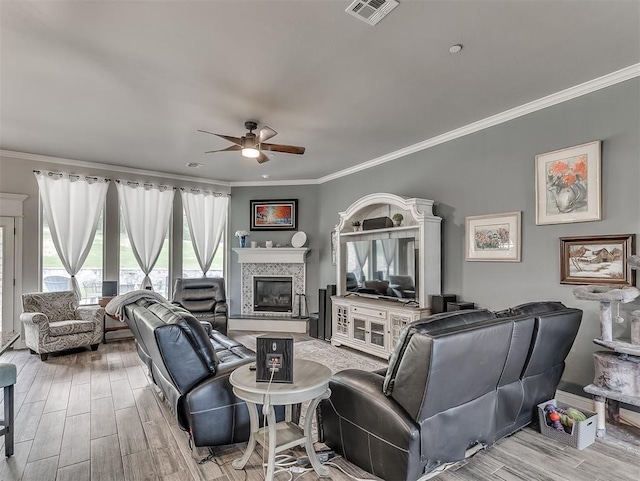 5608 Courtland Ln, Choctaw, OK 73020 - living room featuring ceiling fan, crown molding, light wood finished floors, and a tile fireplace